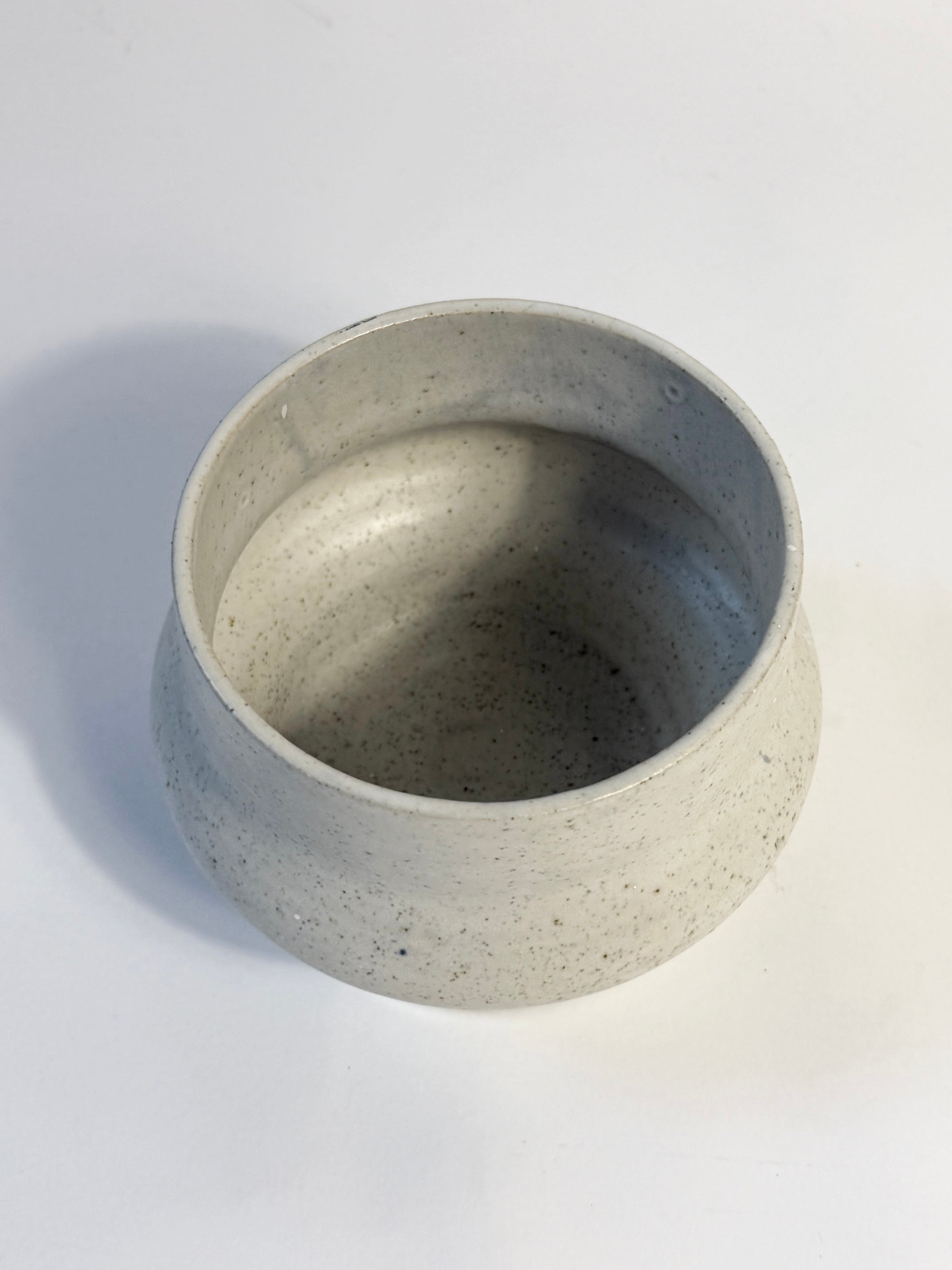 A small round ceramic pot with a speckled light natural finish.  Hand made in Adelaide South Australia by FionaK