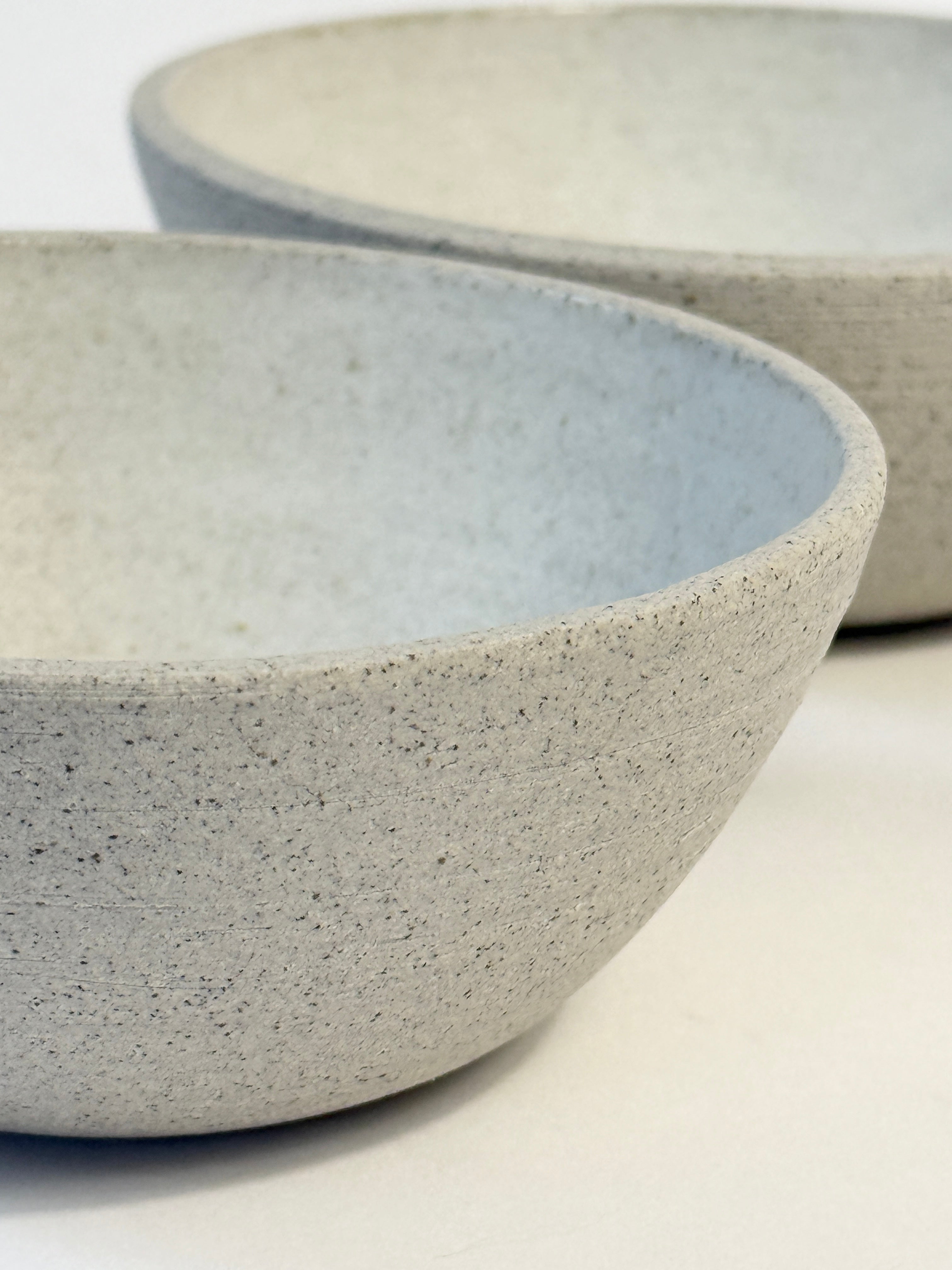 Close up showing the natural unglazed speckled grey clay on the ceramic bowl set.