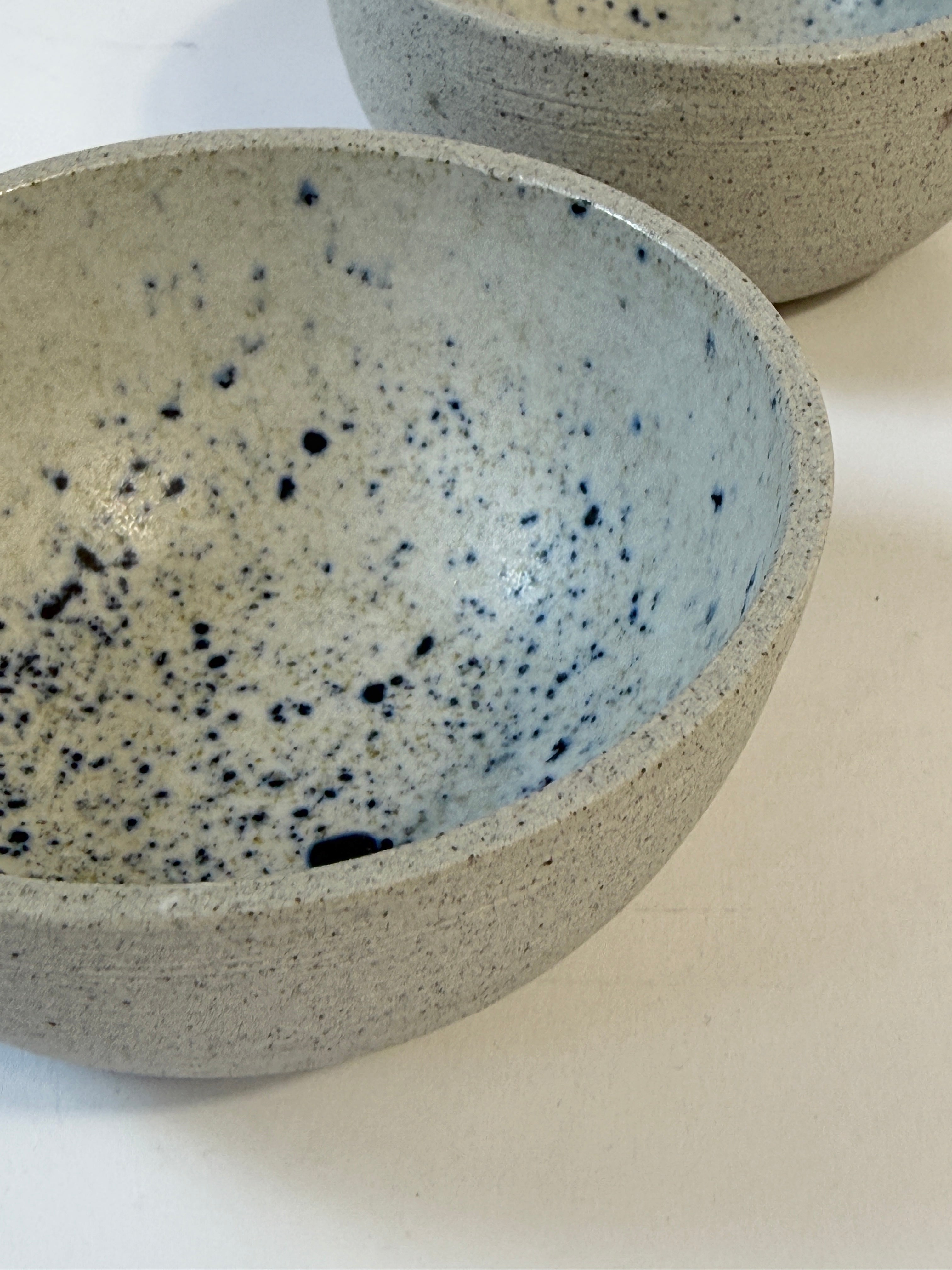 Close up showing the natural unglazed speckled grey clay and glazed interior