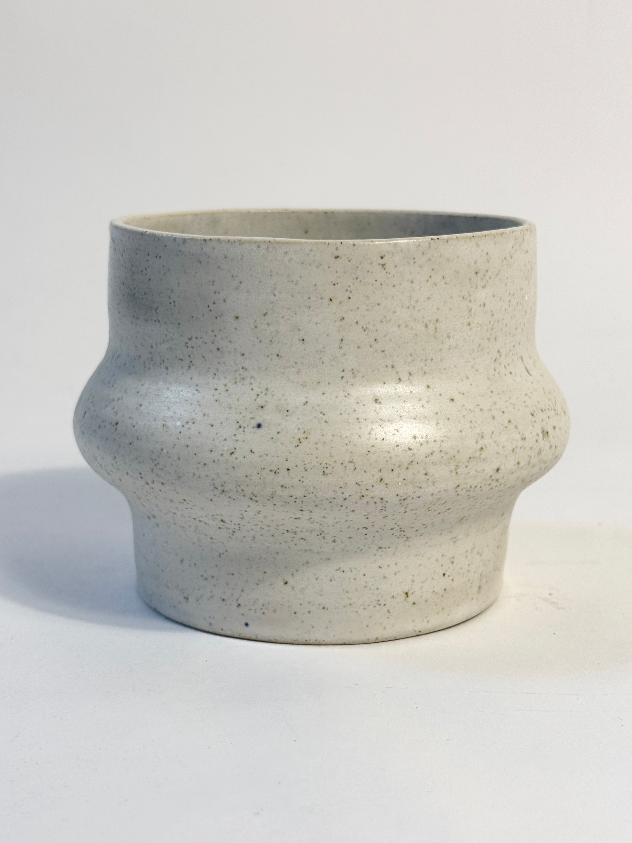 A handmade ceramic pot with a speckled effect with natural tones.  Unusual flared bulbous shape.